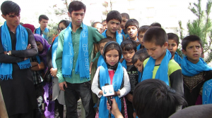 Sakina speaks to a T.V. reporter. Rohullah is on her right, Inam on her left.