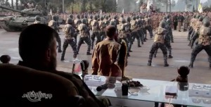 Zahran Alloush watches a military parade of Islam Army fighters from a podium in the Eastern Ghouta, in a propaganda tape released by the group.