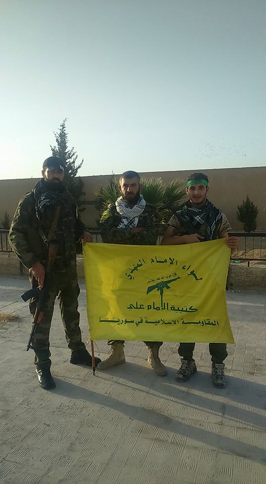 Fighters posing with the flag of Liwa al-Imam al-Mahdi (The Imam Ali Battalion). Identical with the emblem at the top of the article.
