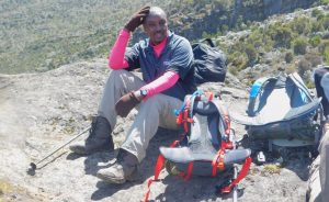 CBK staffer Mr. Gikuhi Ndegwa takes a needed rest on his journey to the summit of Mount Kilimanjaro. Photo Credit: CBK.