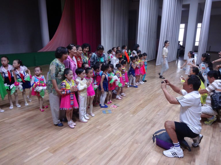 Chinese tourists taking pictures with performers from the children’s concert