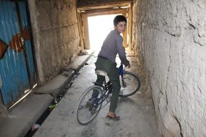 Inaam on his bicycle, near his house and the scene of a suicide bomb attack. Photo Credit: Dr. Hakim Young.