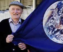 Earth Flag John McConnell in front of his home in Denver, Colorado with the Earth Flag he designed.