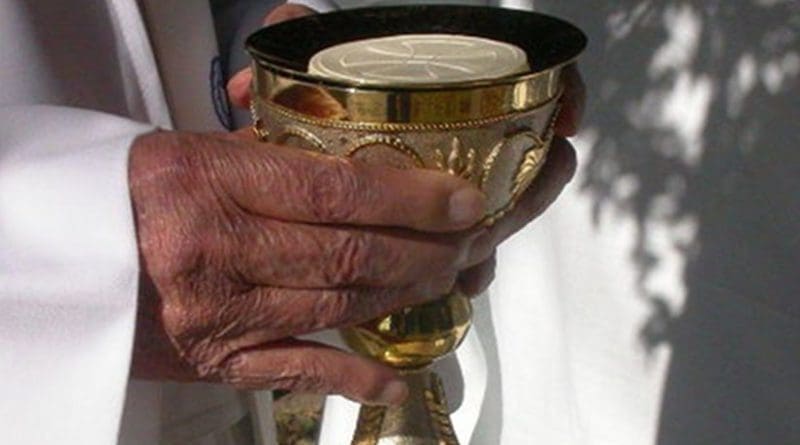 Priest preparing Holy Communion.