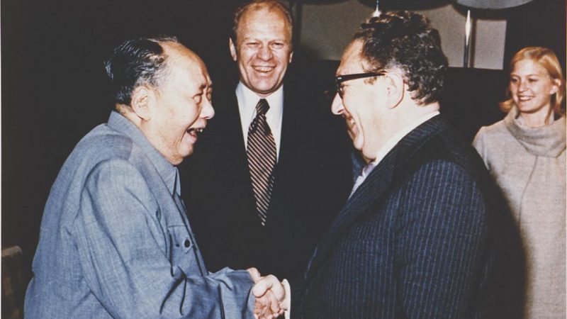 Gerald Ford watches as Henry Kissinger shakes hands with Mao Zedong, December 2, 1975. Photo: Courtesy Gerald R. Ford Library, Wikipedia Commons.