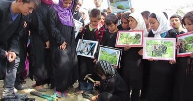 Sakina breaks a toy gun before burying it. Inam and other street kids await their turn.