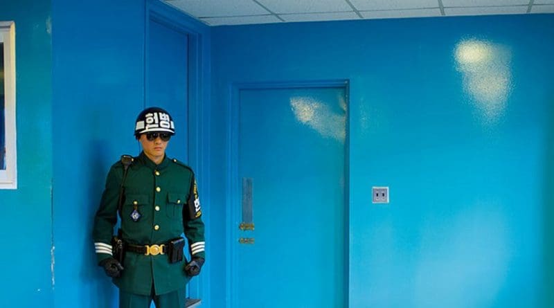 An ROK soldier protects the door to North Korea in the building where the armistice was signed between North and South Korea. Photo by Severin Stalder, Wikipedia Commons.
