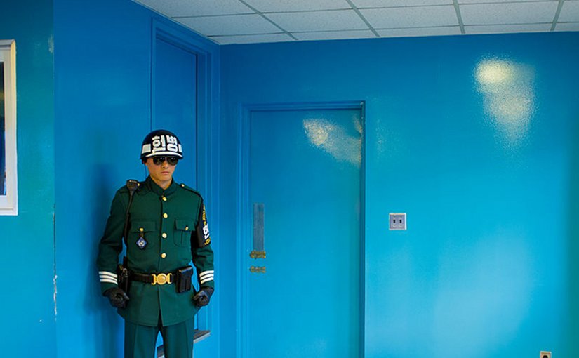 An ROK soldier protects the door to North Korea in the building where the armistice was signed between North and South Korea. Photo by Severin Stalder, Wikipedia Commons.