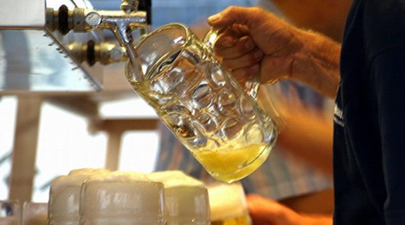 Bartender serving mugs of beer.