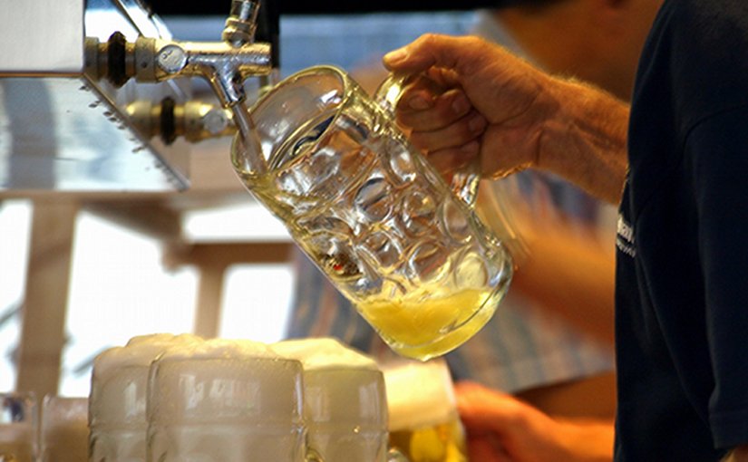 Bartender serving mugs of beer.