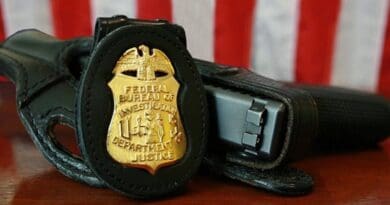FBI badge and gun. Source: Wikipedia Commons.