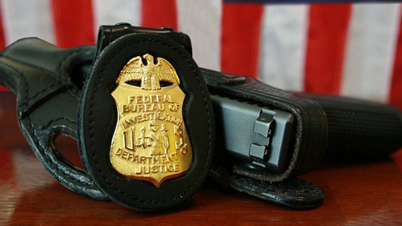 FBI badge and gun. Source: Wikipedia Commons.