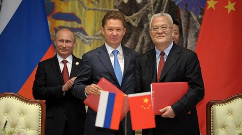 Alexey Miller on behalf of Russia and China sign a USD$ 400 billion dollar gas deal, as Vladimir Putin observes. Photo Credit: Russian presidential Website, Kremlin.ru, Wikipedia Commons.