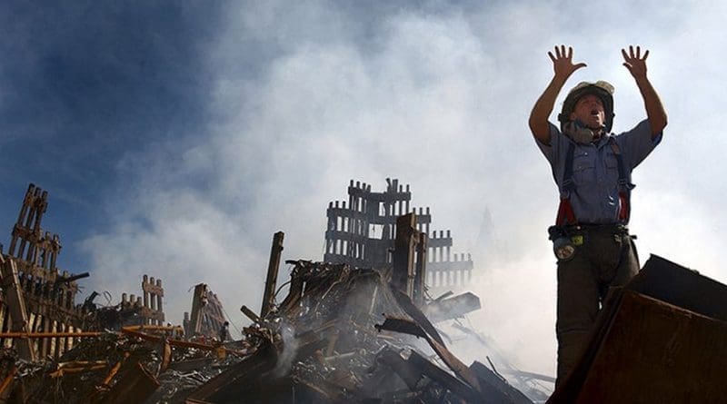 A New York City fireman calls for 10 more rescue workers to make their way into the rubble of the World Trade Center site of the 911 attacks. U.S. Navy Photo by Journalist 1st Class Preston Keres, Wikipedia Commons.