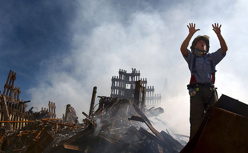 A New York City fireman calls for 10 more rescue workers to make their way into the rubble of the World Trade Center site of the 911 attacks. U.S. Navy Photo by Journalist 1st Class Preston Keres, Wikipedia Commons.