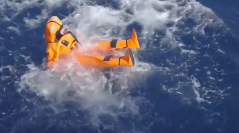 Norway's Minister of Migration and Integration Sylvi Listhaug jumps in the Mediterranean Sea in an orange survival suit.