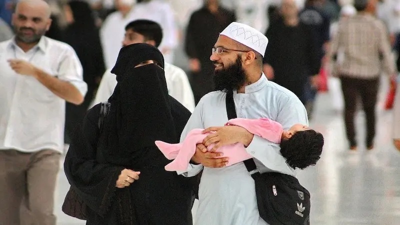 A young Muslim couple and their toddler at Masjid al-Haram, Makkah, Saudi Arabia. Photo by Mohammed Tawsif Salam, Wikipedia Commons.