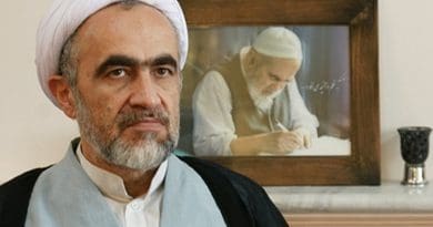 Ahmad Montazeri sits in front of a portrait picture of his late father Hossein Ali Montazeri. Photo via Radio Zamaneh.