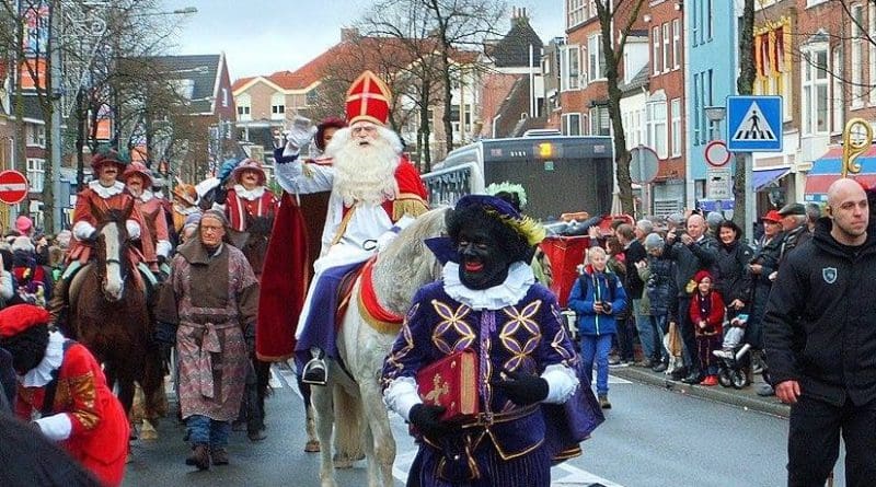 Head Piet carrying the Boek van Sinterklaas on the way from the Steamboat to the City Hall, where they will be officially welcomed by the City Mayor. Photo by Berkh, Wikipedia Commons.