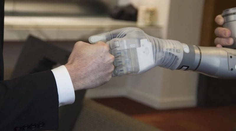 Dr. Justin Sanchez, director of the Defense Advanced Research Projects Agency’s Biological Technologies Office, fist-bumps with one of the first two advanced “LUKE” arms to be delivered from a new production line during a ceremony at Walter Reed National Military Medical Center in Bethesda, Md., Dec. 22, 2016 DoD photo