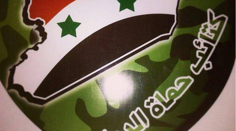 Emblem of Kata’ib Humat al-Diyar, featuring Syria as the main part of the emblem and the group’s name beneath it.