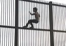 Climbing the Mexico–United States barrier fence in Brownsville, Texas. Photo by Nofx221984, Wikipedia Commons.