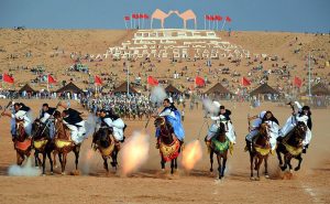 Sahrawi tribal men performing the fantasia at the Tan-Tan Moussem in Tan-Tan, Morocco. Photo by Maxim Massalitin, Wikipedia Commons.