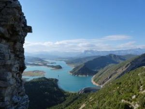 This is a view of the Mediano anticline, strata dipping to the left into the lake waters. This large-scale fold structure is a witness of ancient deformation associated with the rise of the Pyrenees in the middle Eocene, 45 Million years ago. Excellent exposure of rocks in this dry area allow today's geologists to study the epic poem of the Earth written in its sedimentary archives. Credit © UNIGE