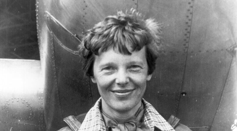 Amelia Earhart standing under nose of her Lockheed Model 10-E Electra. Photo Credit: Wikimedia Commons.