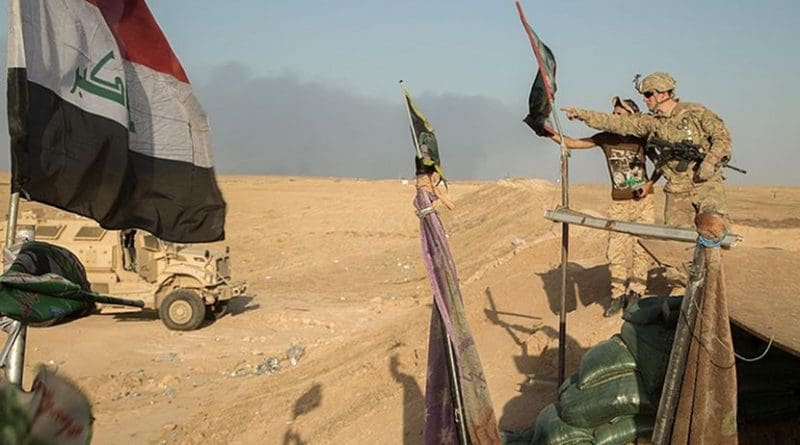 A U.S. soldier of the 101st Airborne Division and a member of the Iraqi Special Operations Forces discuss assessment of Iraqi security force checkpoints. U.S. Army photo by Spc. Christopher Brecht, Wikipedia Commons.