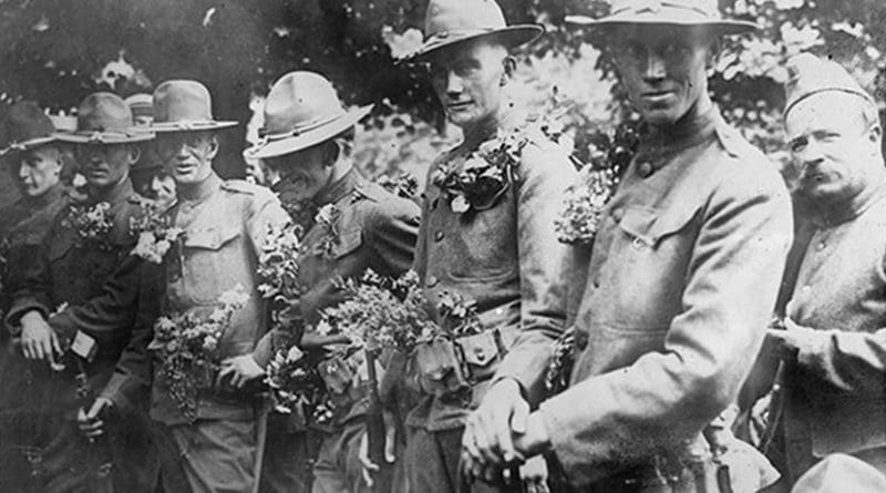 U.S. soldiers at the Picpus cemetery in Paris, where the Marquis de Lafayette is buried, are covered in flowers during a Bastille Day celebration in France, circa 1917-1920. Library of Congress photo