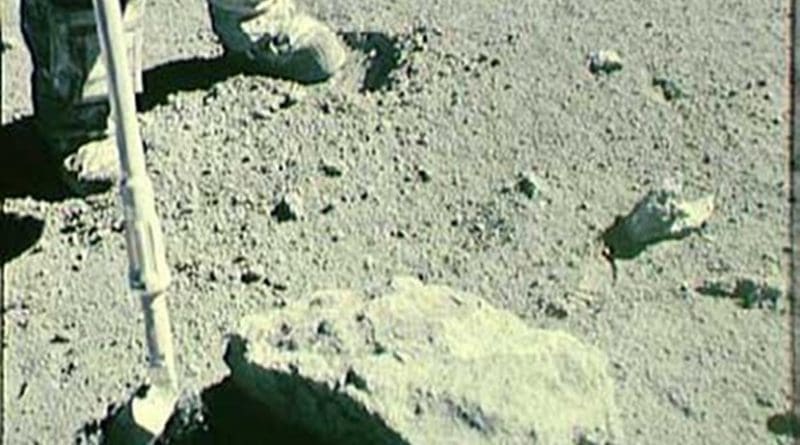Image of the collection of the Rusty Rock, 66095, on the lunar surface by lunar module pilot, Charlie Duke and commander John Young. April 1972. Credit NASA