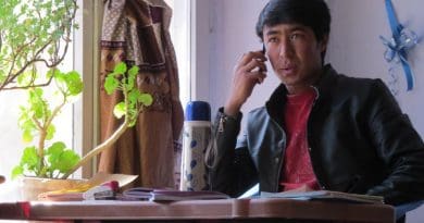 Ghulam at his study desk in Kabul, calling to make sure his family members were well, in the minutes following a bomb blast nearby