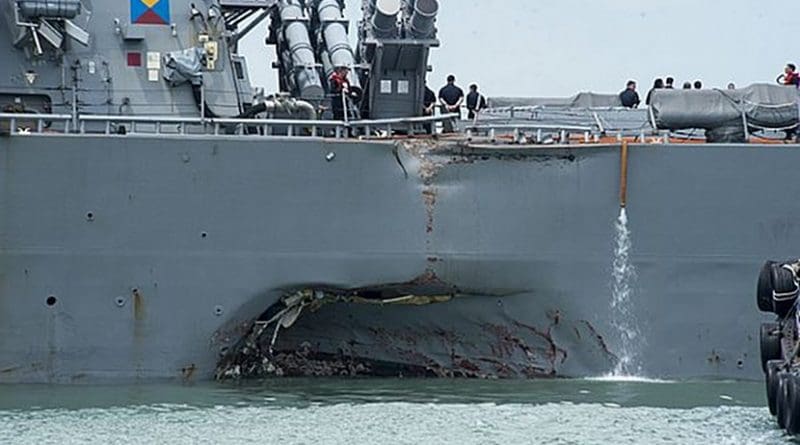 Damage to the portside is visible as the guided-missile destroyer USS John S. McCain (DDG 56) steers towards Changi Naval Base, Republic of Singapore, following a collision with the merchant vessel Alnic MC while underway east of the Straits of Malacca and Singapore. U.S. Navy photo by Mass Communication Specialist 2nd Class Joshua Fulton.