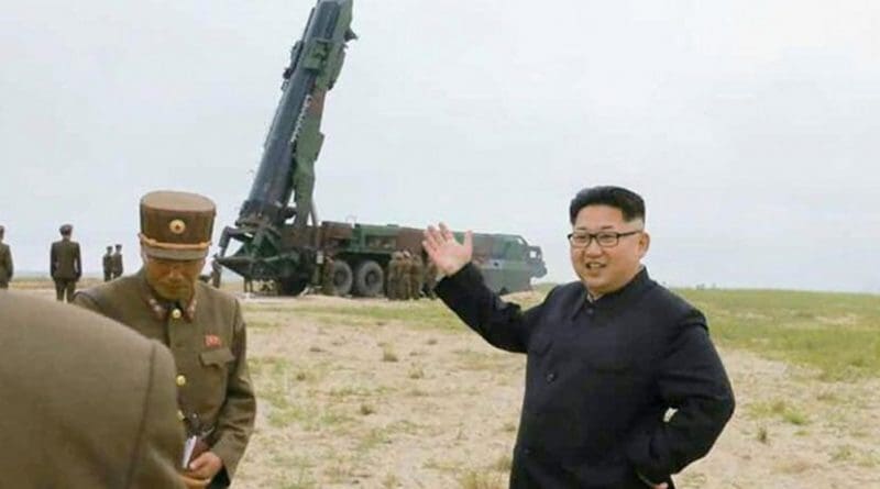 North Korea's Kim Jong Un in front of a missile launcher.