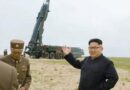 North Korea's Kim Jong Un in front of a missile launcher.