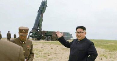 North Korea's Kim Jong Un in front of a missile launcher.