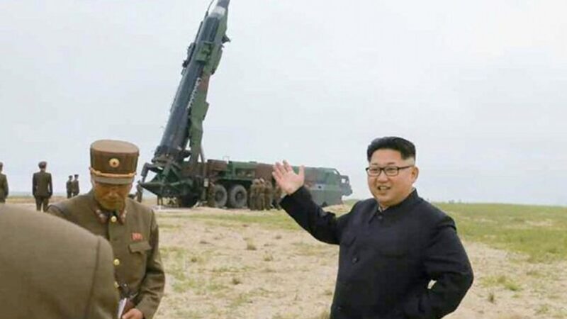 North Korea's Kim Jong Un in front of a missile launcher.