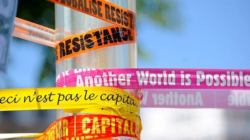 Anti-capitalism and anti-globalization banners. Photo by Guillaume Paumier, Wikimedia Commons.