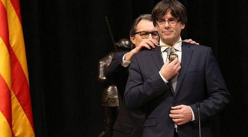 Catalan leader Carles Puigdemont assuming the position of President, in front of his predecessor Artur Mas. Photo Credit: Generalitat de Catalunya, Wikipedia Commons.