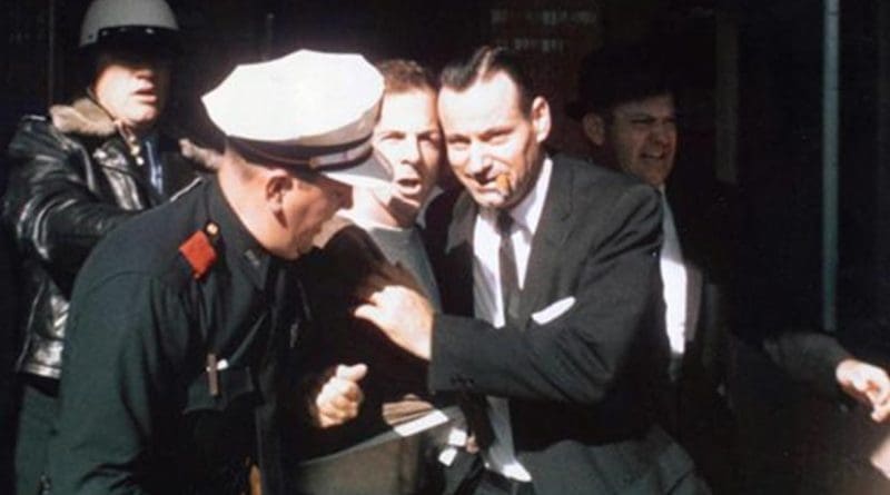 Lee Harvey Oswald being led from the Texas Theatre following his arrest. Photo by Gerald Hill, Wikipedia Commons.