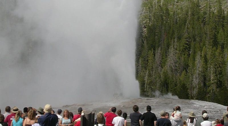 Tourists watch Old Faithful geyser in Yellowstone National Park in Wyoming, United States.