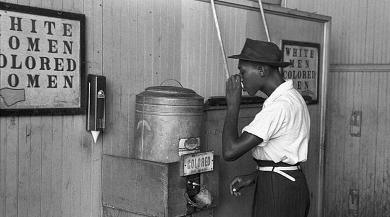 An African-American man drinking at a "colored" drinking fountain in a streetcar terminal in Oklahoma City, 1939. Photo by Russell Lee, Wikipedia Commons.