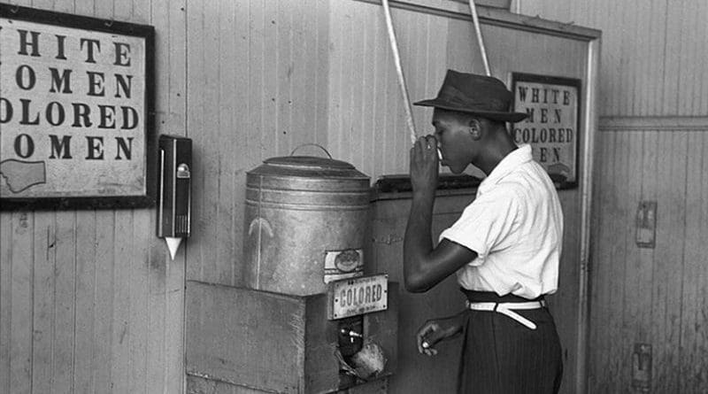 An African-American man drinking at a "colored" drinking fountain in a streetcar terminal in Oklahoma City, 1939. Photo by Russell Lee, Wikipedia Commons.