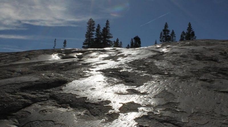 Glacial polish reflects sunlight at Pothole Dome in Yosemite National Park, California. The granitic bedrock here was polished by glacier sliding during the Last Glacial Maximum. UCSC researchers found that glacial polish forms by the accretion of a thin coating layer on top of glacially abraded surfaces. Credit Shalev Siman-Tov