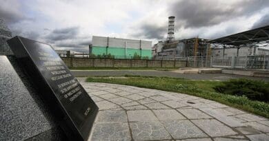 Chernobyl Nuclear Power Plant reactor number 4, the enclosing sarcophagus and the sign in the shelter object construction memorial monument. Photo by Matti Paavonen, Wikipedia Commons.