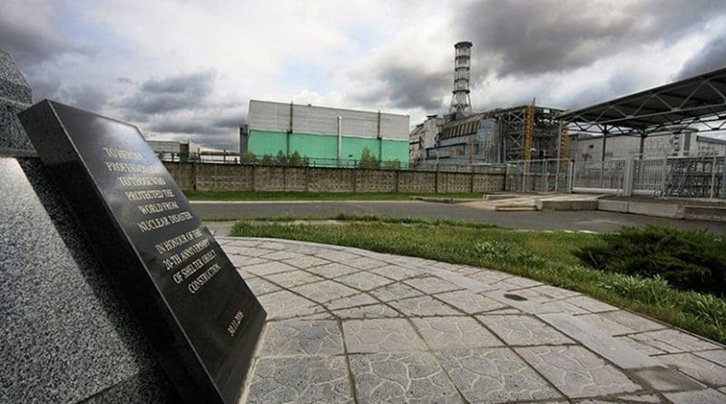 Chernobyl Nuclear Power Plant reactor number 4, the enclosing sarcophagus and the sign in the shelter object construction memorial monument. Photo by Matti Paavonen, Wikipedia Commons.