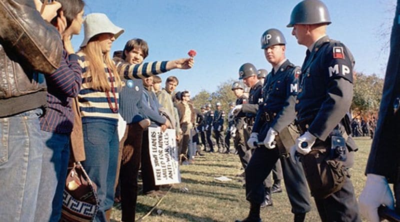 A female demonstrator offers a flower to military police on guard at the Pentagon during an anti-Vietnam demonstration. Arlington, Virginia, USA. Photo by S.Sgt. Albert R. Simpson. Department of Defense, Wikipedia Commons.