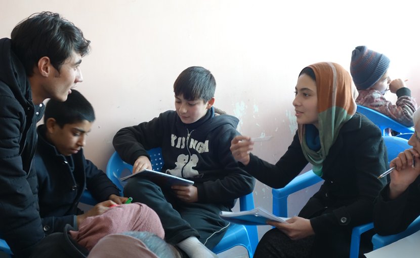 Mursal interacts with her teacher Naser during a Friday afternoon Bridge class, encouraging Street Kid School soon-to-be-graduates to volunteer at the Borderfree Centre. Photo credit: Carolyn Coe