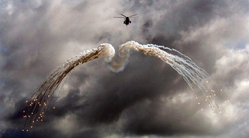 A Canadian CH 124 Sea King helicopter from HMCS Ville de Québec (VDQ) fires off defensive flares during an exercise above the Indian Ocean. Photo by MCpl Kevin Paul, Canadian Forces Combat Camera.